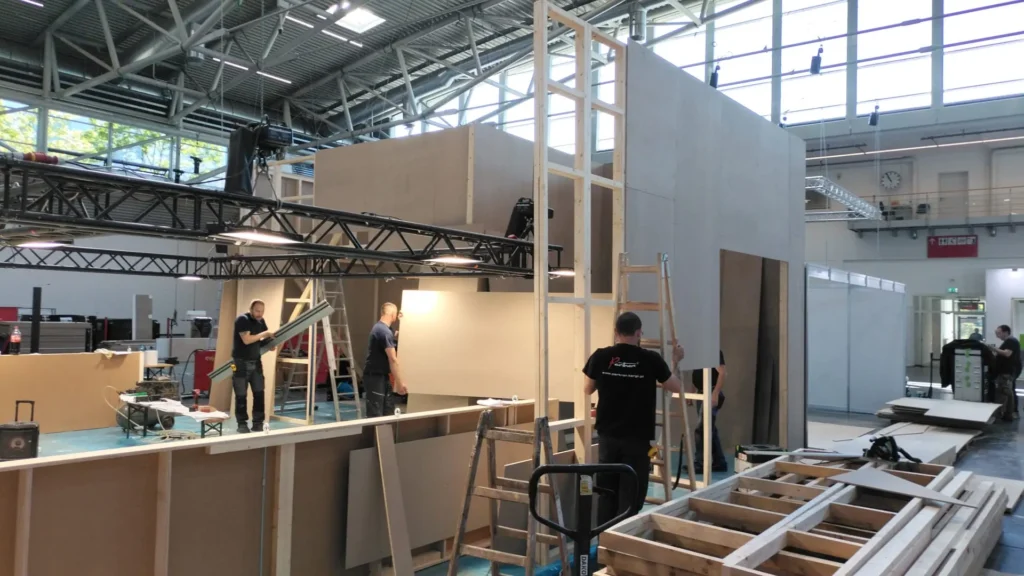 Construction workers assembling Array's exhibition stand designed and built by Booth Exhibits™.