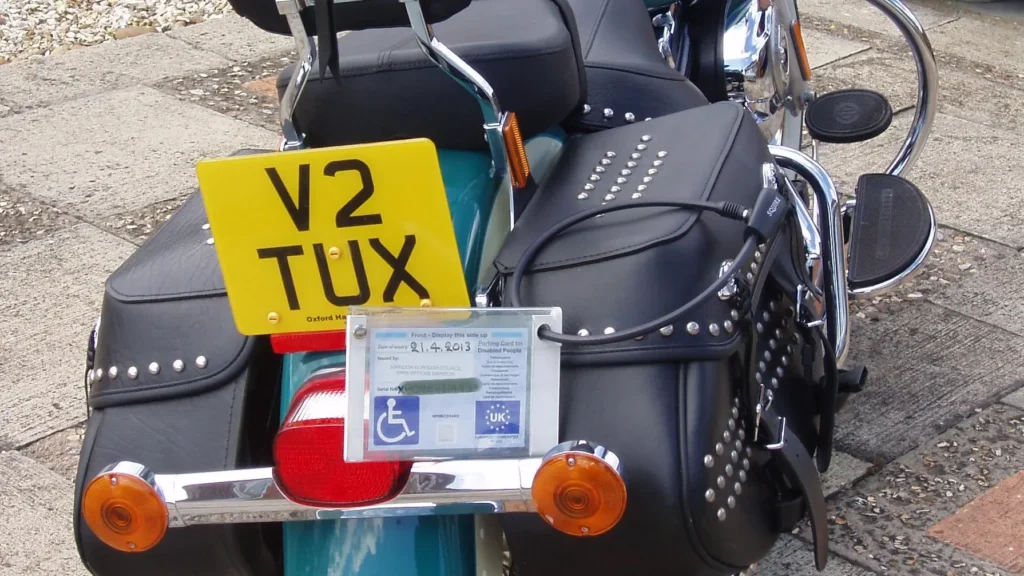 A motorcycle with a blue disabled parking badge at the rear.