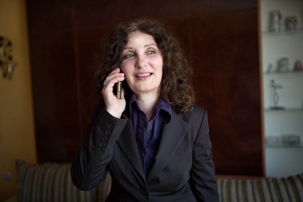 Woman in suit talking on phone.