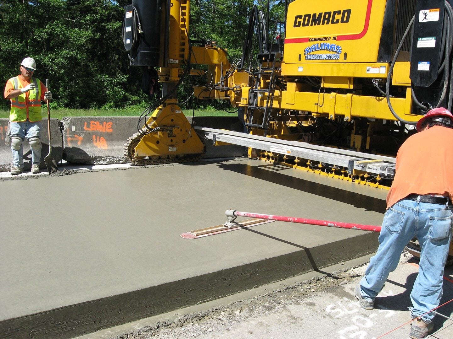A worker using a machine to level the concrete.