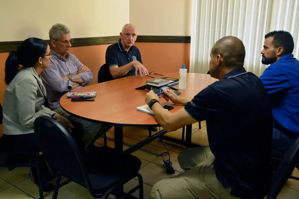 A group of people discuss matters at a table. 