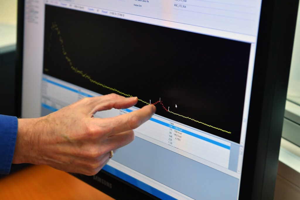 Hand pointing at data on screen.