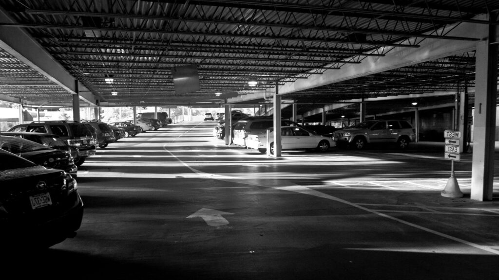 A black and white shot of an undercover parking lot.