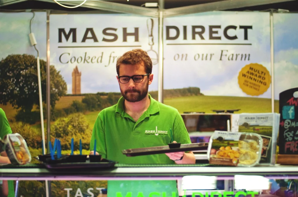 An exhibitor at the Royal Highland Show with a tray of food samples.