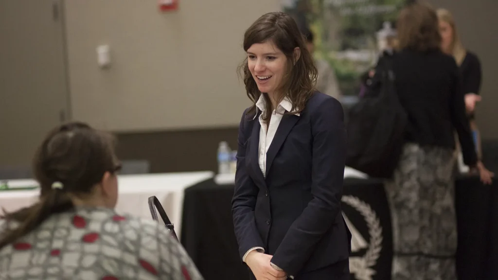 A conversation between two people at a professional networking event.