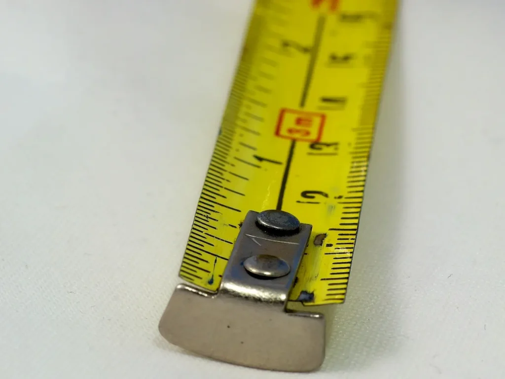 The end of a yellow metal tape measure. 