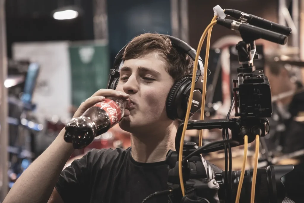 A drummer takes a sip of Coca-Cola during a break.