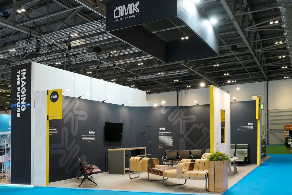 OMK trade show booth featuring OMK's own furniture products as seating, built by Booth Exhibits™ in London. 