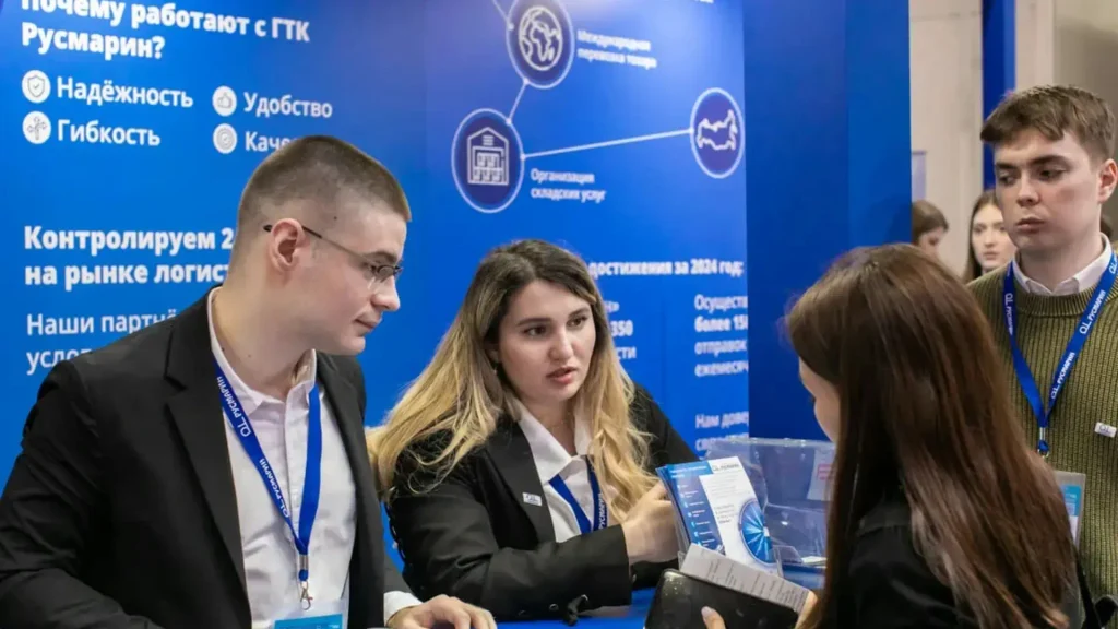 A simple exhibition stand with two staff members talking to an attendee. 
