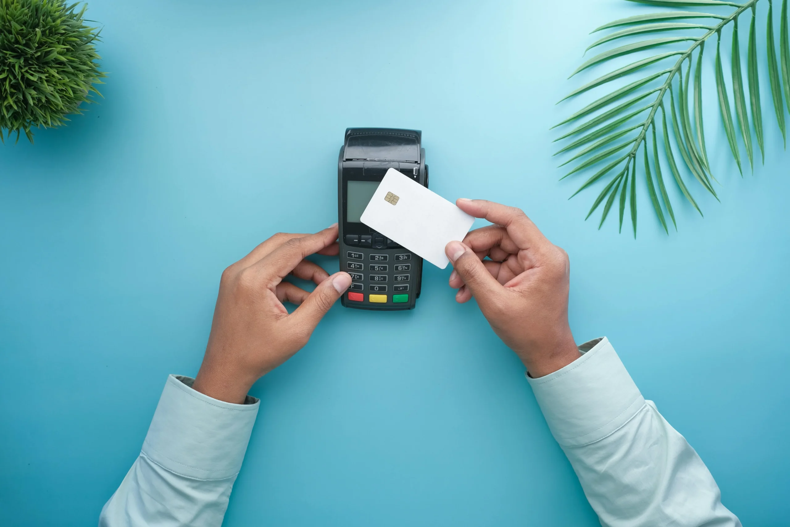 A person tapping their contactless bank card on a payment machine.